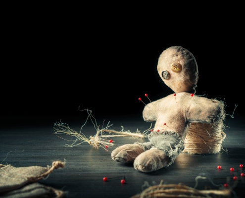 Voodoo Doll With Dramatic Lighting On A Wooden Background